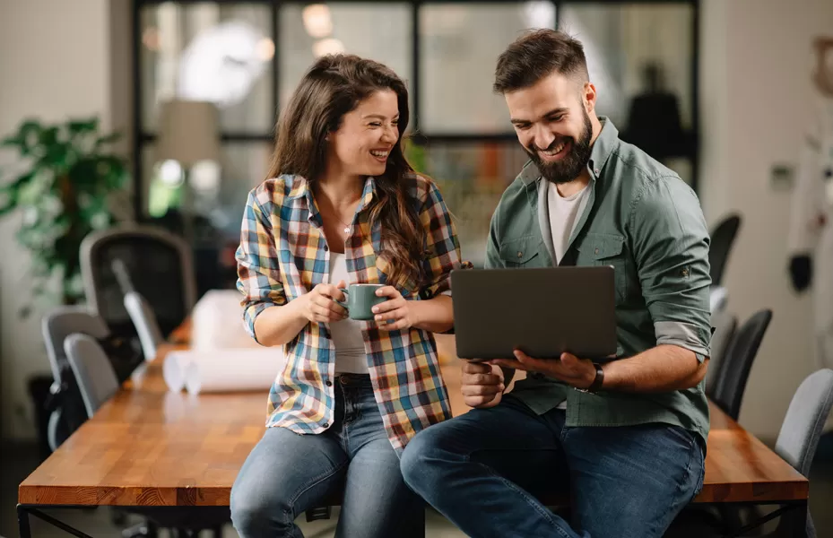 Man and woman sitting behind a laptop