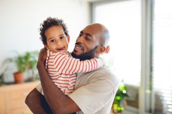 Man holding baby hugging and smiling