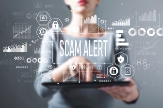 The words Scam Alert with woman on an tablet